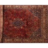 A Joshagan carpet:, the brick red field with a central indigo stepped lozenge pole medallion,