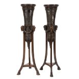 A pair of carved walnut and cane panelled torcheres:,