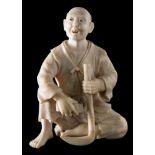 A Japanese carved ivory okimono: of a peasant farmer sharpening his scythe, unsigned, Meiji period,