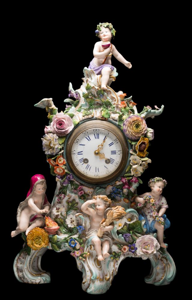 A Meissen porcelain mantel clock: in the form of four allegorical putti representing the four