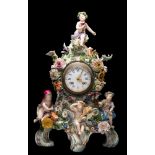 A Meissen porcelain mantel clock: in the form of four allegorical putti representing the four