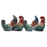 A group of four Chinese porcelain cockerel and hen groups: each in sitting posture under red, green,