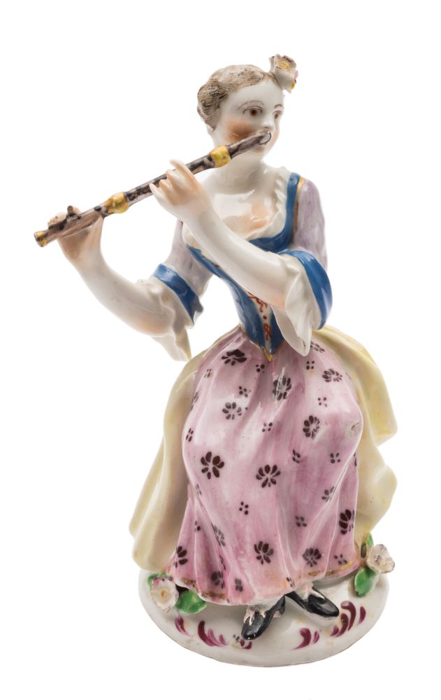 A Bow figure of a seated lady flautist: wearing a yellow cloak,