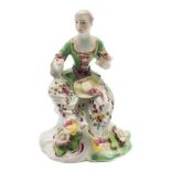 An early Derby 'pale family' figure of a seated lady: wearing a puce and gilt trimmed green bodice,