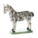 An English creamware model of a horse: with sponged grey markings,