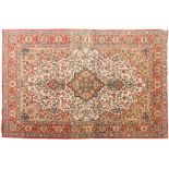 A Qum rug:, the ivory cartouche field with a central light brown flowerhead pole medallion,