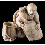 A Japanese carved ivory okimono: of a fisherman handling a turtle, with a basket by his side,