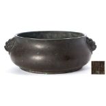 A Chinese bronze censer: of compressed globular form with mythical beast mask handles,