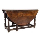 An 18th Century oak oval gateleg dining table:, with a hinged top,