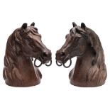 A pair of cast iron and bronze patinated busts: of horse's heads, each wearing a bit, unsigned 25.