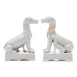 Two Chinese blanc de Chine dogs: each modelled seated with a puppy at its side,