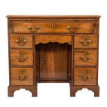 A George III mahogany kneehole desk:, the rectangular top with a moulded edge, fitted with a slide,