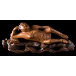 A Chinese carved boxwood doctor's female medicine doll: reclining on a pillow,