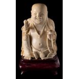 A late 19th century Chinese carved ivory figure of a seated Buddah: wearing loose robes and adorned