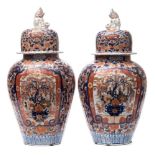 A pair of Japanese Imari porcelain jars and covers: of lobed oviform the domed covers with shi shi