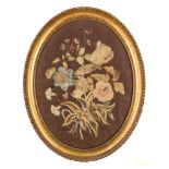 A 19th Century oval silkwork panel: depicting a bird amongst flowers,