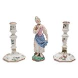 A Hochst [Damm] faience figure of a girl and a pair of Continental tin-glazed candlesticks: the
