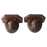 A pair of small carved oak wall brackets: with winged cherub supports, 18cm.