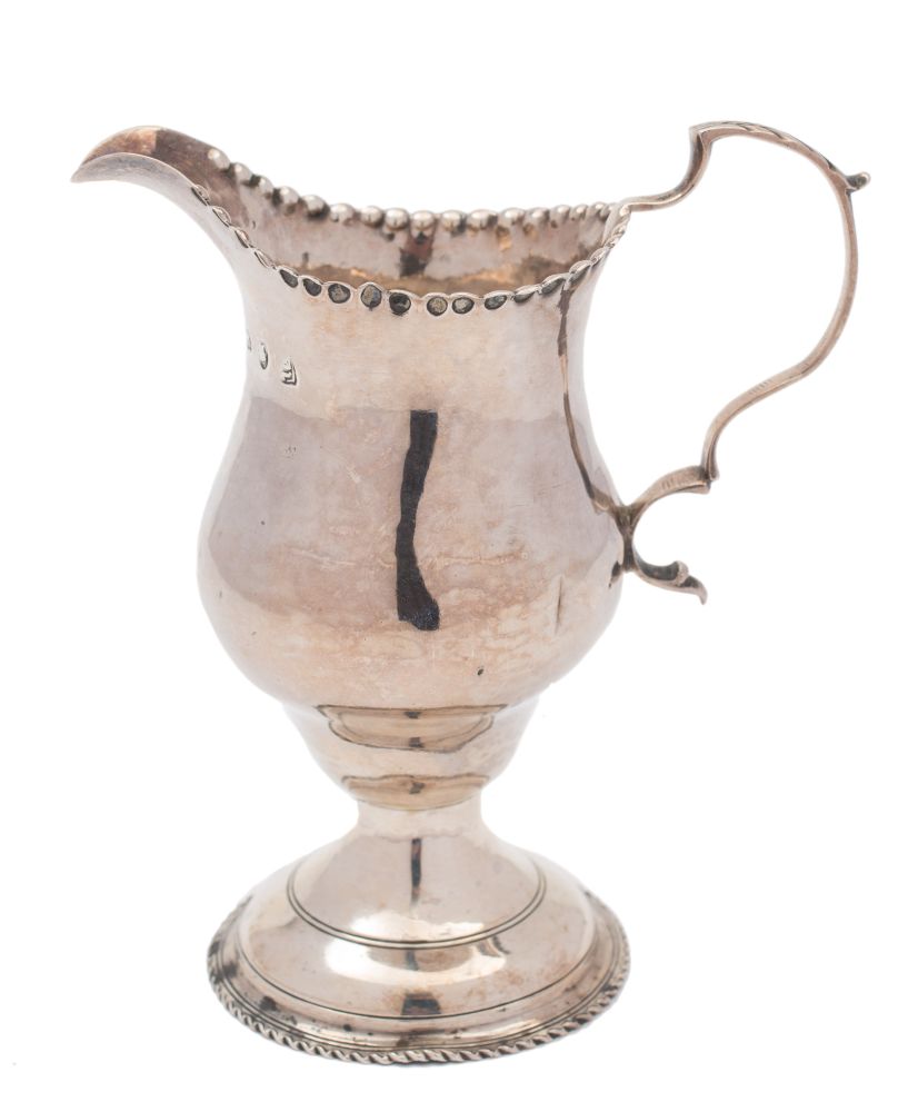 An early George III silver pedestal cream jug: of baluster form and double scroll handle,