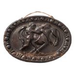 A 17th/18th Century carved walnut oval plaque: depicting Herakles attacking a centaur within an egg