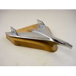 A 1957 Chevrolet chrome plated car mascot:, on later wooden base 35cm long.