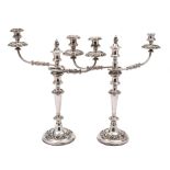 A pair of plated twin-branch candelabra: with urn-shaped nozzles on reeded and swept branches,