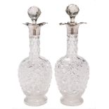 A pair of George V clear glass and silver mounted decanters and stoppers,