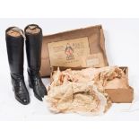 A pair of black leather riding boots with beech trees:,