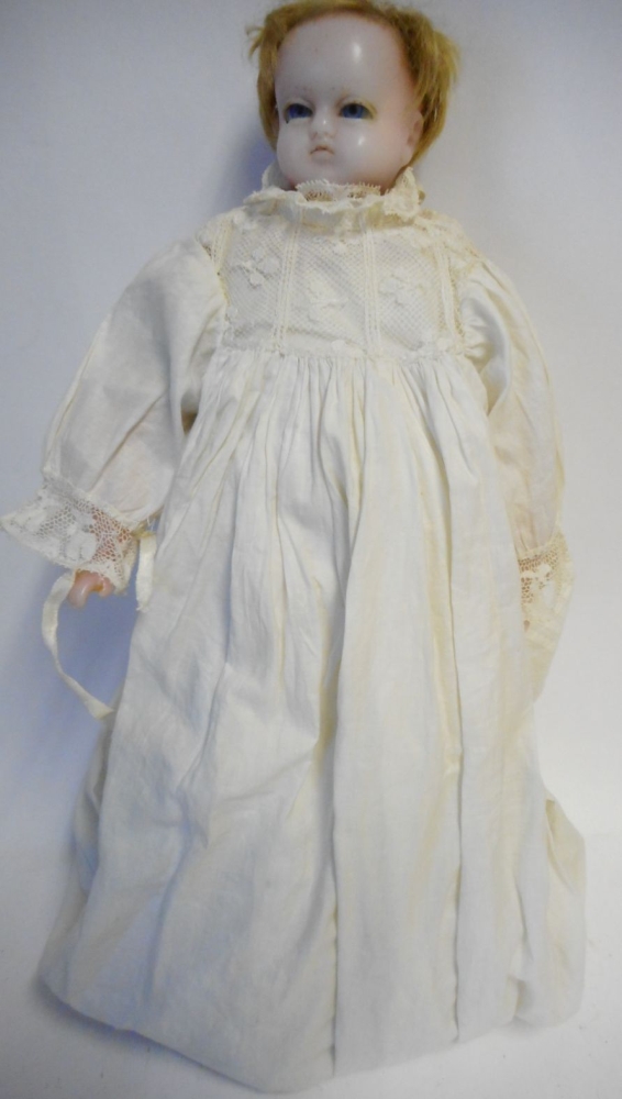 A French wax head doll: with fair mohair wig, blue paperweight eyes, on a cloth body with wax limbs,