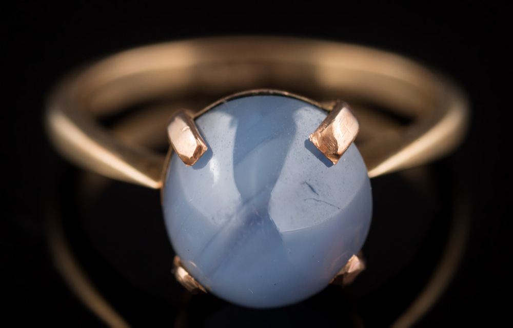 A star sapphire mounted single-stone ring: the star sapphire approximately 9.8mm long x 9.