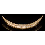 A late 19th/early 20th century rose diamond and half pearl mounted crescent brooch: with graduated