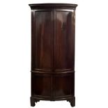 A late 18th/early 19th Century mahogany bow-fronted standing corner cupboard:,