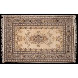 A Kashmiri rug:, the ivory field with a central indigo shaped medallion and floral foliate designs,