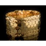 An 18ct gold wide bracelet: of plain and textured honeycomb linking, 36mm wide, 81gms gross weight.