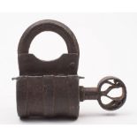 An antique iron lock and key: of barrel shaped outline with turn-screw action, 11cm. high.