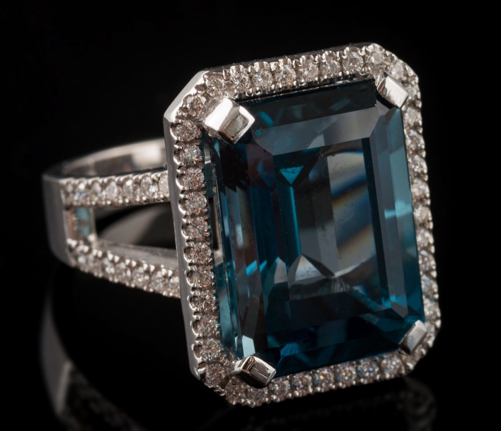 A London blue topaz and diamond rectangular cluster ring: the emerald-cut topaz approximately 15.