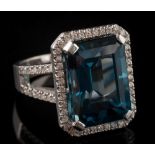 A London blue topaz and diamond rectangular cluster ring: the emerald-cut topaz approximately 15.