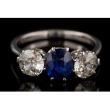 A sapphire and diamond three-stone ring: with central oval sapphire between round old brilliant-cut