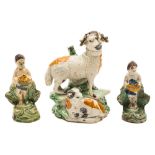 Three creamware press moulded figures: comprising a ram and lamb group and two figures holding
