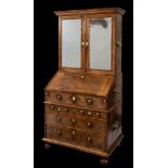 A William and Mary walnut veneer and feather banded bureau cabinet:, in three sections,