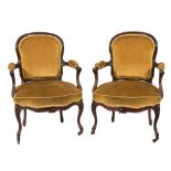 A pair of Victorian carved rosewood armchairs in the Louis XV taste:,