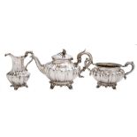 A matched silver three-piece tea service, various maker's and dates: of fluted melon-shaped outline,