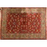 A Persian carpet:, the rust field with an all over design of palmettes and stylised floral foliage,