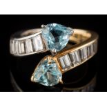 A heart-shaped aquamarine two-stone crossover ring: with heart-shaped aquamarines between shoulders