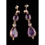 A pair of amethyst four-stone drop earrings: each suspending a pear-shaped drop in cut-down collet