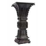 A large Chinese bronze vase, Gu: of square section, the corners with pierced vertical flanges,