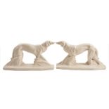 A pair of French Art Deco pottery figures of Borzois: each standing in alert pose on elongated