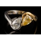 A pear-shaped natural fancy yellow diamond and diamond two-stone cross over ring: the pear-shaped