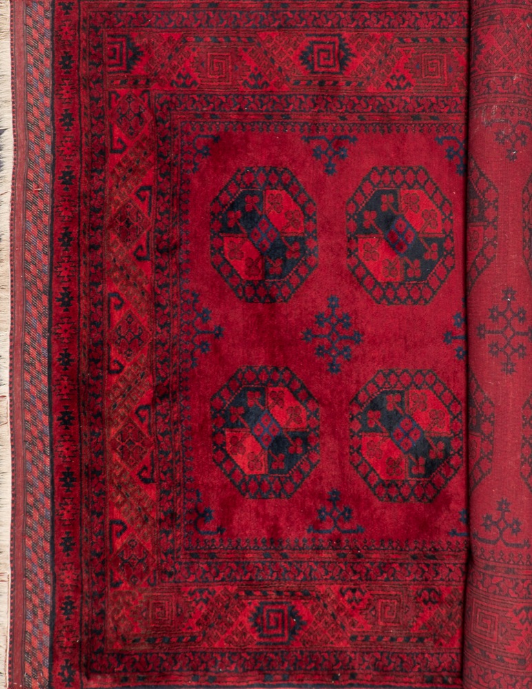 An Afghan carpet:, of traditional design and colours,