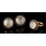 A pair of moonstone and sapphire circular cluster earrings: each with a single circular moonstone